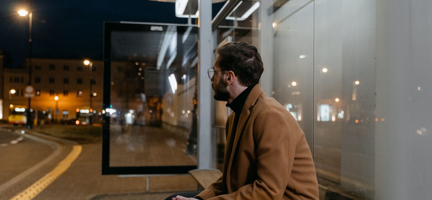 man waiting at a bus stop.