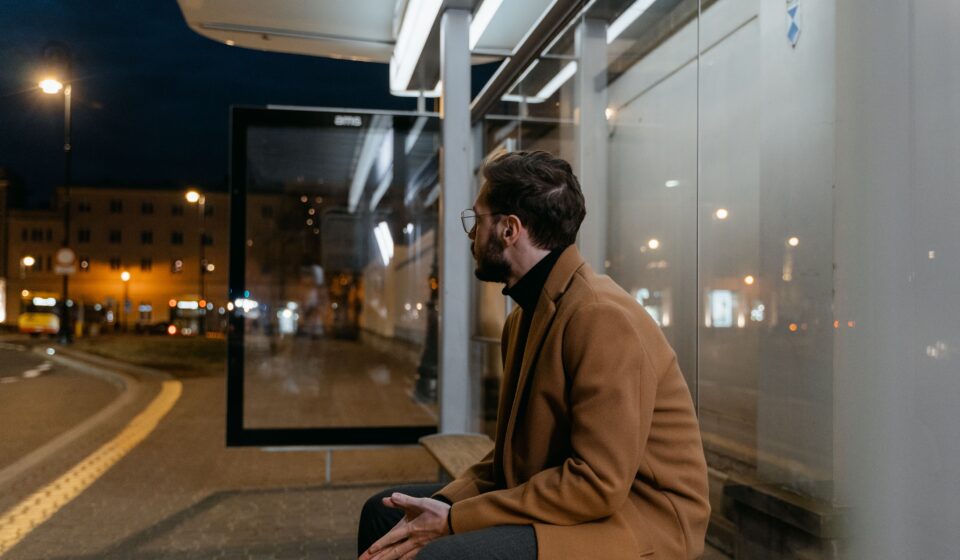 man waiting at a bus stop.